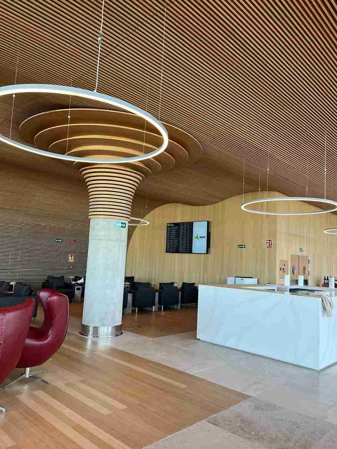 The Sala VIP Valldemossa at Palma de Mallorca Airport features a seating area with armchairs and a central information display.