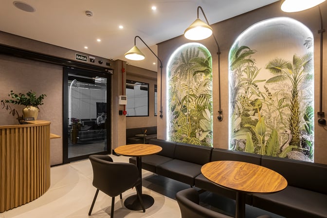 The seating area at W Café Lounge Palmas features round tables, cushioned chairs, and decorative wall panels with botanical designs.