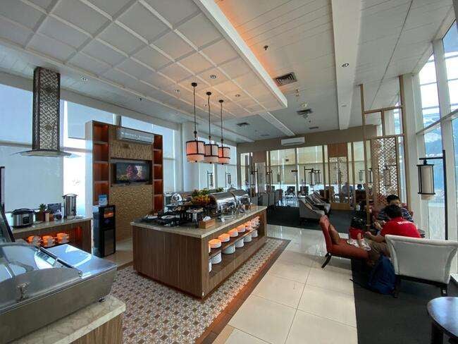 The Saphire Lounge at Depati Amir Airport features a self-serve food station with seating areas for travelers to relax and dine.