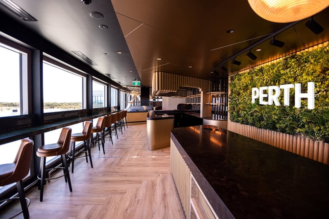 The International Aspire Lounge at Perth Airport features counter seating with large windows offering views of the runway.