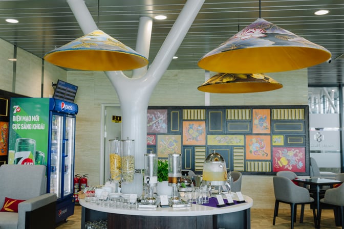 The SH Premium Lounge at Phu Bai International Airport features a self-serve beverage station with cereals, juices, and soft drinks.
