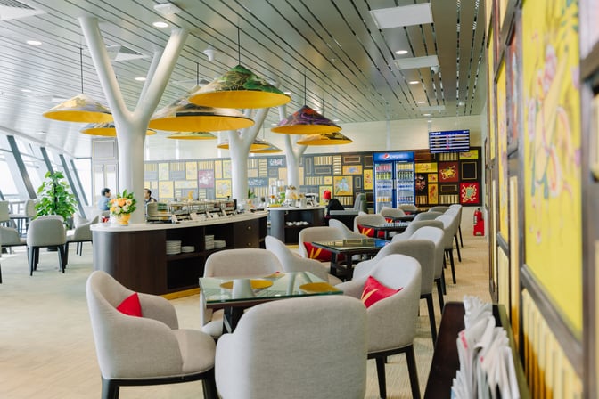 The SH Premium Lounge at Phu Bai International Airport features a buffet area with seating and a beverage station.