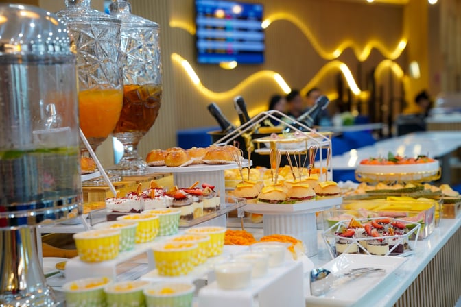 The food area at Lotus Lounge, Phu Cat Airport, features a variety of self-serve snacks, desserts, and beverages for guests.