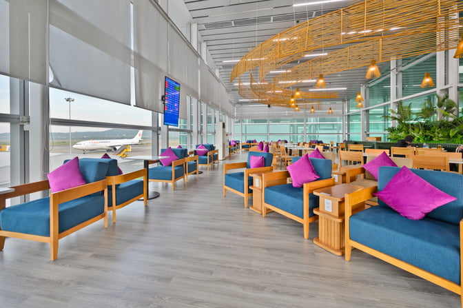 The SH Premium Lounge at Phu Quoc International Airport features spacious seating with views of the runway and flight information displays.