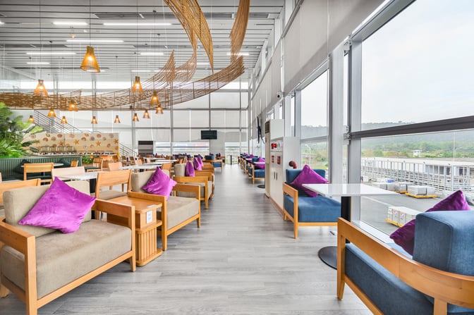 The SH Premium Lounge at Phu Quoc International Airport features spacious seating with tables, offering views of the airport tarmac.