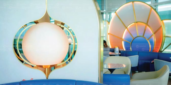 Seating area in the SENS Leisure Lounge at Phu Quoc International Airport features curved booths and tables for passenger comfort.