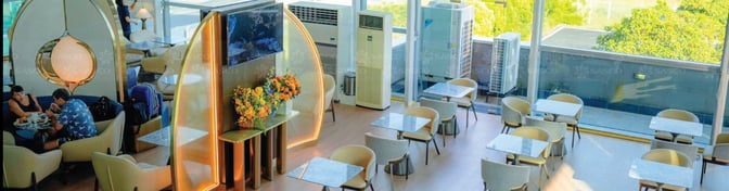 The SENS Leisure Lounge at Phu Quoc International Airport features dining tables and seating with views of the surrounding area.