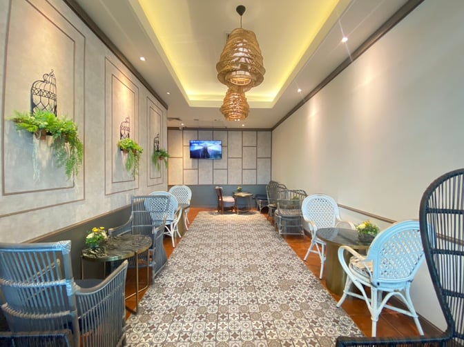 The seating area in Bangkok Airways Blue Ribbon Lounge at Phuket International Airport features wicker chairs and small tables for relaxation.