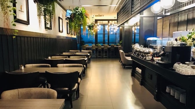 The Coral Premium Departure Lounge at Phuket International Airport features a dining area with table seating and a self-serve buffet station.