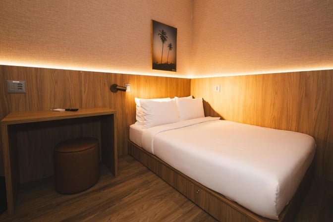 The W Airport Rooms at Fortaleza International Airport feature a compact sleeping area with a bed, desk, and seating.