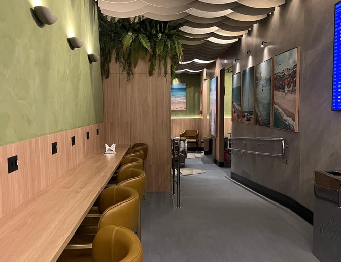 The W Premium Lounge at Fortaleza International Airport features a counter seating area with power outlets and decorative wall art.