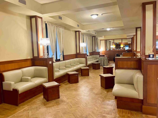 The Galilei VIP Lounge at Pisa International Airport features cushioned seating areas with small tables, providing a comfortable waiting space for travelers.