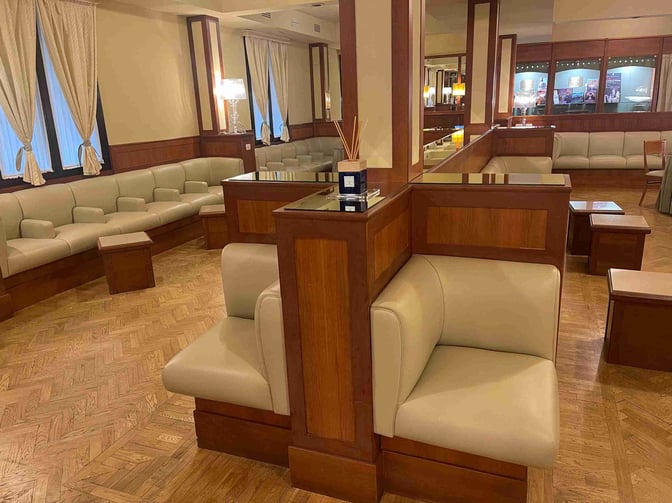 The Galilei VIP Lounge at Pisa International Airport features comfortable seating areas with cushioned chairs and small tables for travelers.