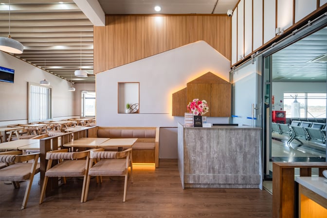 The SH Premium Lounge at Pleiku Airport features a reception area with seating and tables for dining and relaxation.