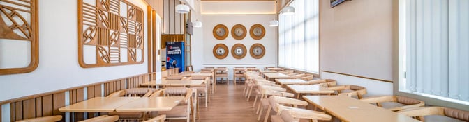 The seating area in SH Premium Lounge Pleiku features multiple tables and chairs, providing ample space for dining and relaxation.