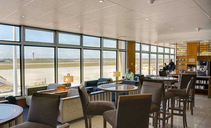The Bidvest Premier Lounge at Port Elizabeth International Airport features seating with airport views and a self-serve coffee station.