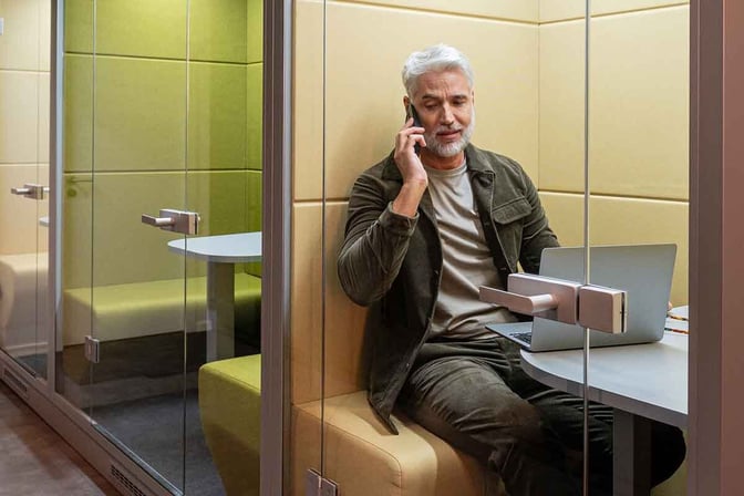 Private work booths at the Mastercard Lounge in Prague Airport offer seating, a small table, and privacy for phone calls.