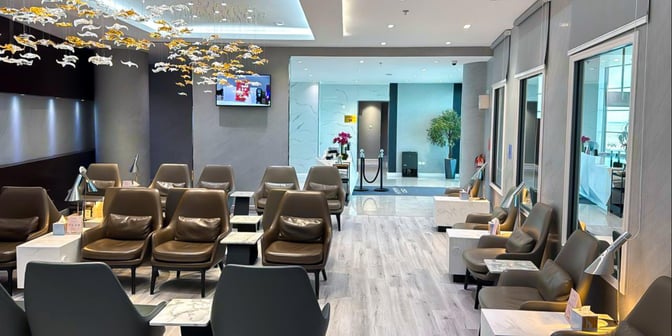 The seating area in Hayyak Lounge at Prince Abdul Mohsin bin Abdulaziz International Airport features comfortable chairs and small tables with reading lamps.