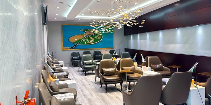 The seating area in Hayyak Lounge at Prince Abdul Mohsin bin Abdulaziz International Airport features comfortable chairs and individual tables with lamps.
