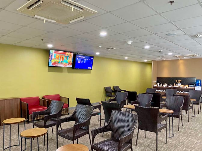 The PAGSS Lounge at Puerto Princesa International Airport features seating with small tables and a self-serve snack and beverage area.