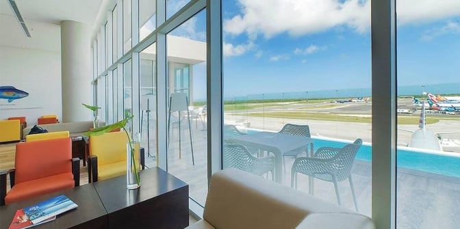 The VIP Lounge at Punta Cana International Airport features seating with views of the runway and an outdoor patio area.