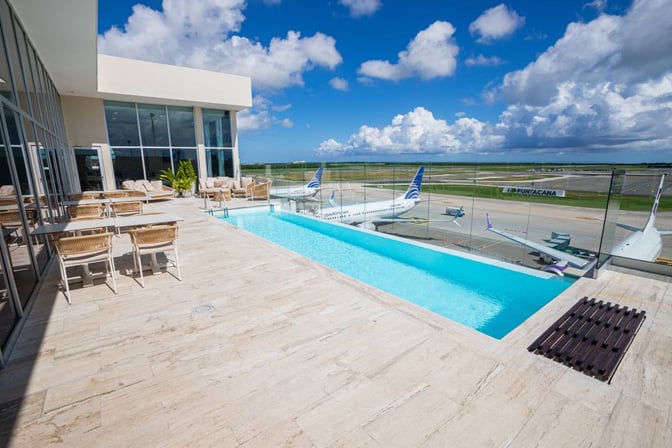 The VIP Lounge at Punta Cana International Airport features an outdoor terrace with seating and a pool overlooking the runway.