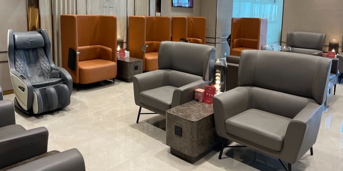 The seating area in Hayyak Lounge at Qaisumah–Hafar Al-Batin International Airport features comfortable chairs and a massage chair for relaxation.