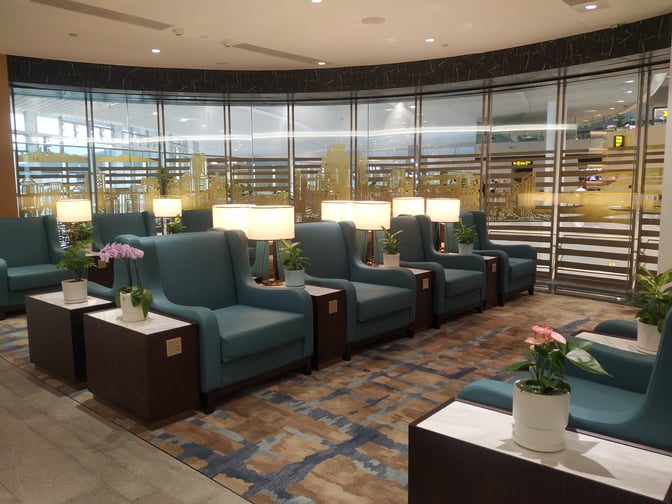 The Trovk Waiting Room at Qingdao Jiaodong International Airport features comfortable seating with side tables and lamps, providing a relaxing environment.