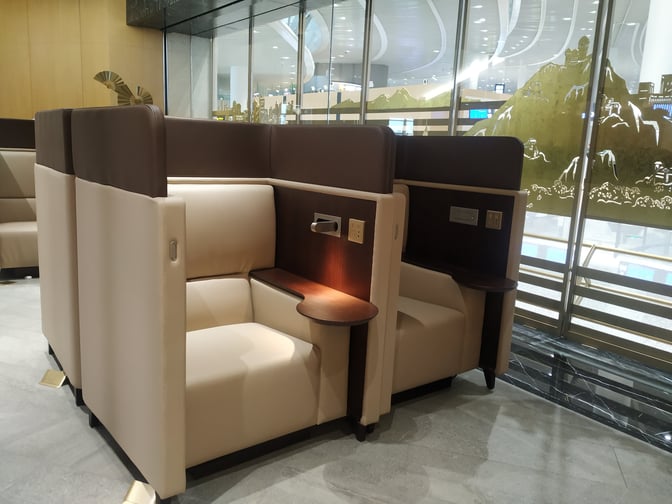 The Trovk Waiting Room at Qingdao Jiaodong International Airport features semi-private seating with individual power outlets and small side tables.