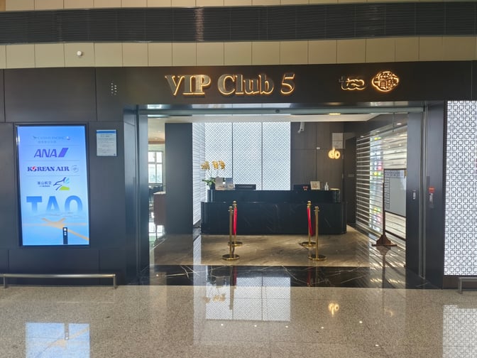The entrance to VIP Club 5 at Qingdao Jiaodong International Airport features a reception desk and airline partnership signage.