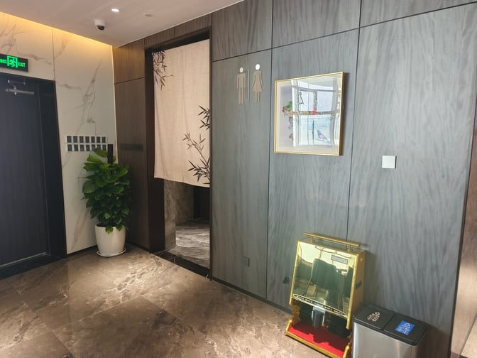 The entrance to the restroom area in the VIP Club 5 features signage and a decorative curtain.