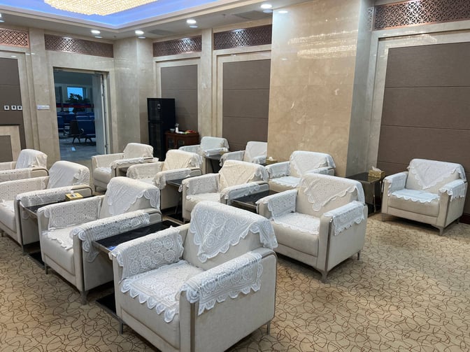 The seating area in the First Class Lounge at Shache Ye'erqiang Airport features armchairs with lace covers and small tables.