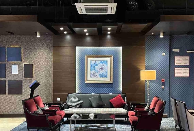 Seating area in Petra Lounge at Queen Alia International Airport features armchairs and a sofa around a central coffee table.