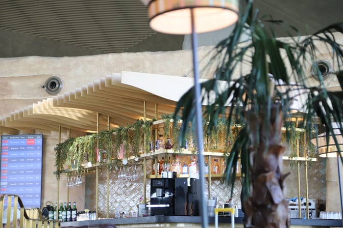 The bar area at Plaza Premium Lounge in Queen Alia International Airport features a selection of spirits and hanging glassware.
