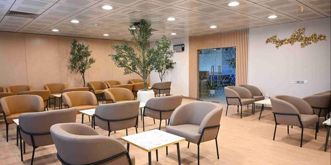 The seating area at Ras Al Khaimah International Airport Lounge features comfortable chairs and small tables, providing a relaxing space for travelers.