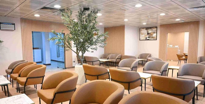 The seating area at Ras Al Khaimah International Airport Lounge features comfortable chairs and tables, providing a relaxing space for travelers.