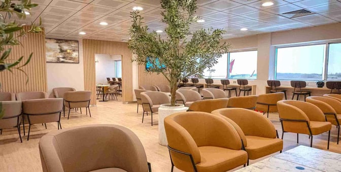 The seating area at Ras Al Khaimah International Airport Lounge features comfortable chairs and tables with views of the runway.
