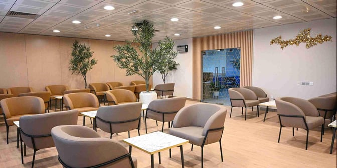 The seating area at Ras Al Khaimah International Airport Lounge features comfortable chairs and small tables, providing a relaxing space for travelers.