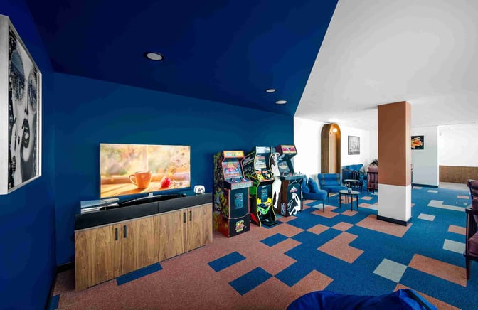 The Kepler Club lounge at Riga International Airport features arcade machines and seating areas for relaxation and entertainment.