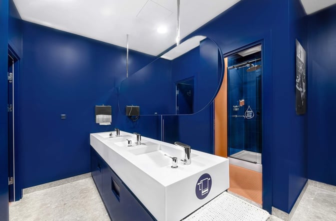 The restroom area in the Kepler Club at Riga International Airport features dual sinks and an adjacent shower facility.