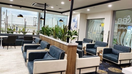 The seating area in Blueberry Premium Lounge at Robert Mugabe International Airport features armchairs and tables with views of the tarmac.