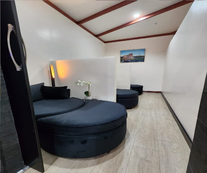 Private seating area at Vhakacha Lounge, Robert Mugabe International Airport, featuring round cushioned seats and a small decorative plant.