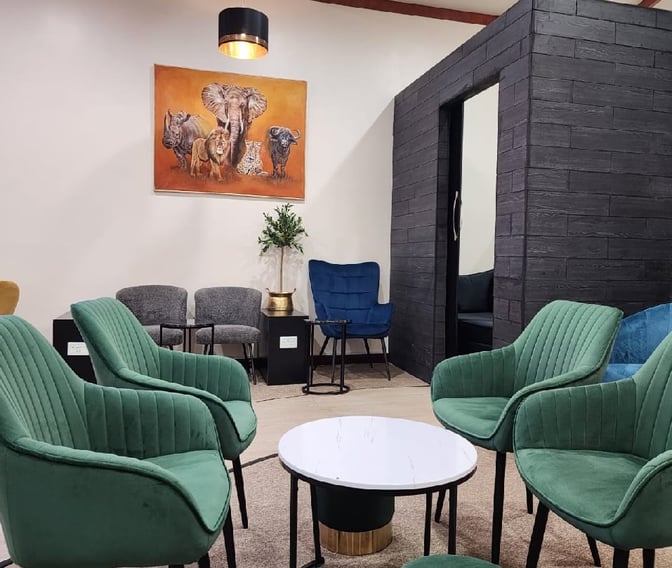 Seating area in Vhakacha Lounge at Robert Mugabe International Airport features comfortable chairs and a small table for relaxation.