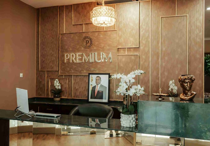 The reception area of the Premium Luxury Lounge at Robert Mugabe International Airport features a desk with decorative elements and a portrait.