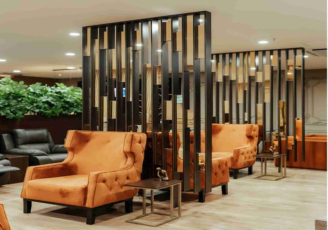 Seating area in the Premium Luxury Lounge at Robert Mugabe International Airport features plush armchairs and small side tables for relaxation.