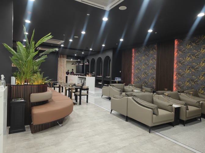 The lounge at Robert Mugabe International Airport features a seating area with armchairs and a bar counter for refreshments.