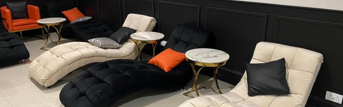 The lounge at Robert Mugabe International Airport features reclining chairs with side tables, providing a comfortable seating area for travelers.