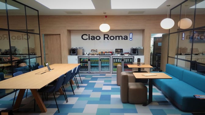 The HelloSky lounge at Leonardo da Vinci-Fiumicino Airport features a self-serve beverage station with seating for dining and relaxation.