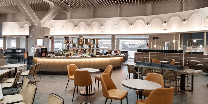 The Plaza Premium Lounge at Leonardo da Vinci-Fiumicino Airport features a central bar with seating and a variety of refreshments.