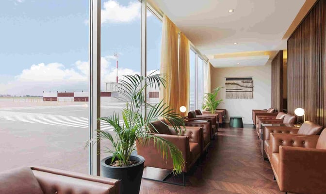 The AMAE Lounge at Rosario - Islas Malvinas International Airport features comfortable seating with views of the airport tarmac through large windows.